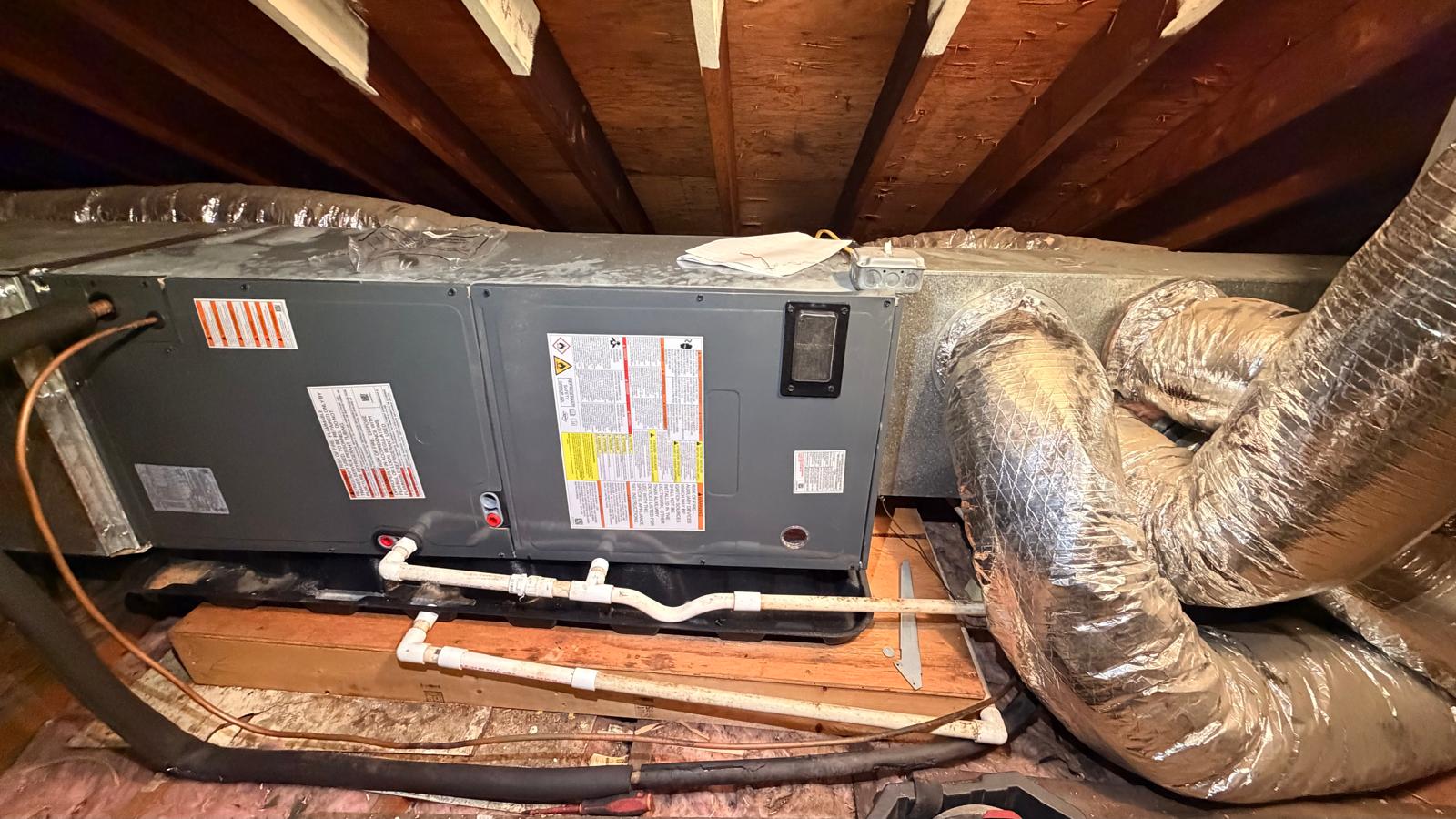 Central HVAC air handler with ductwork in a residential attic